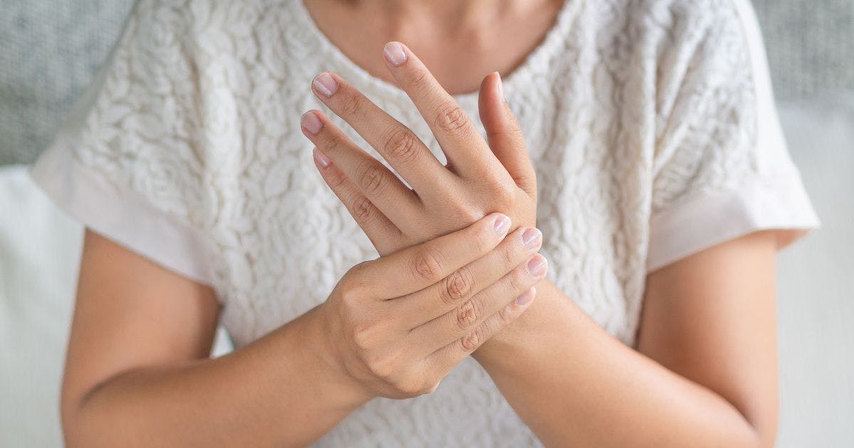 woman with arthritis holding her hand