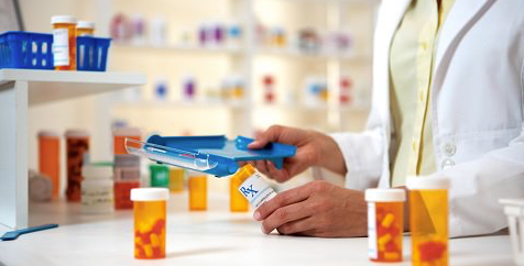 pharmacy counter with pill bottles and a person in a lab coat