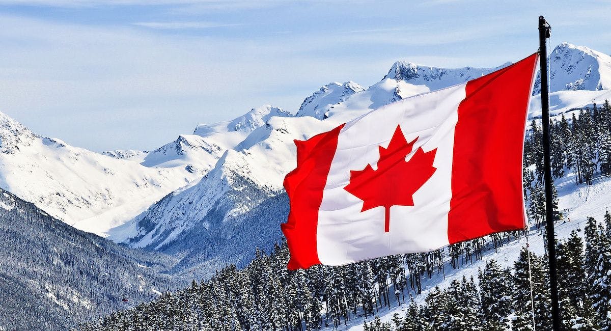 canada flag on a mountain covered in snow