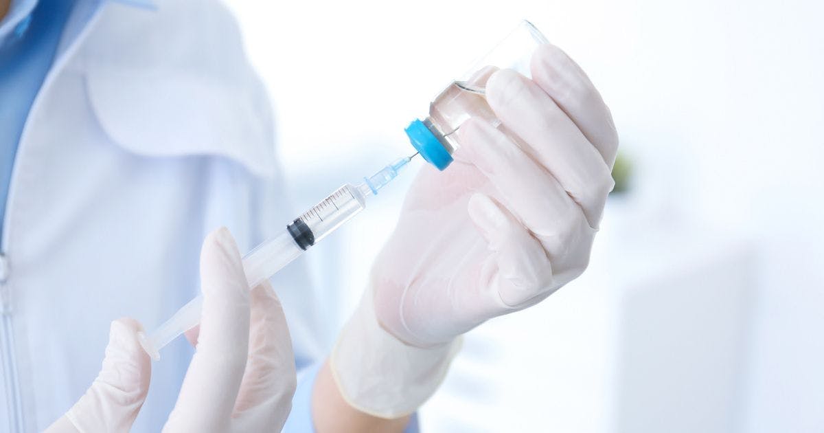 doctor filling syringe from vial