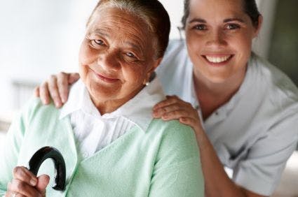 an older woman and a nurse smile at the camera