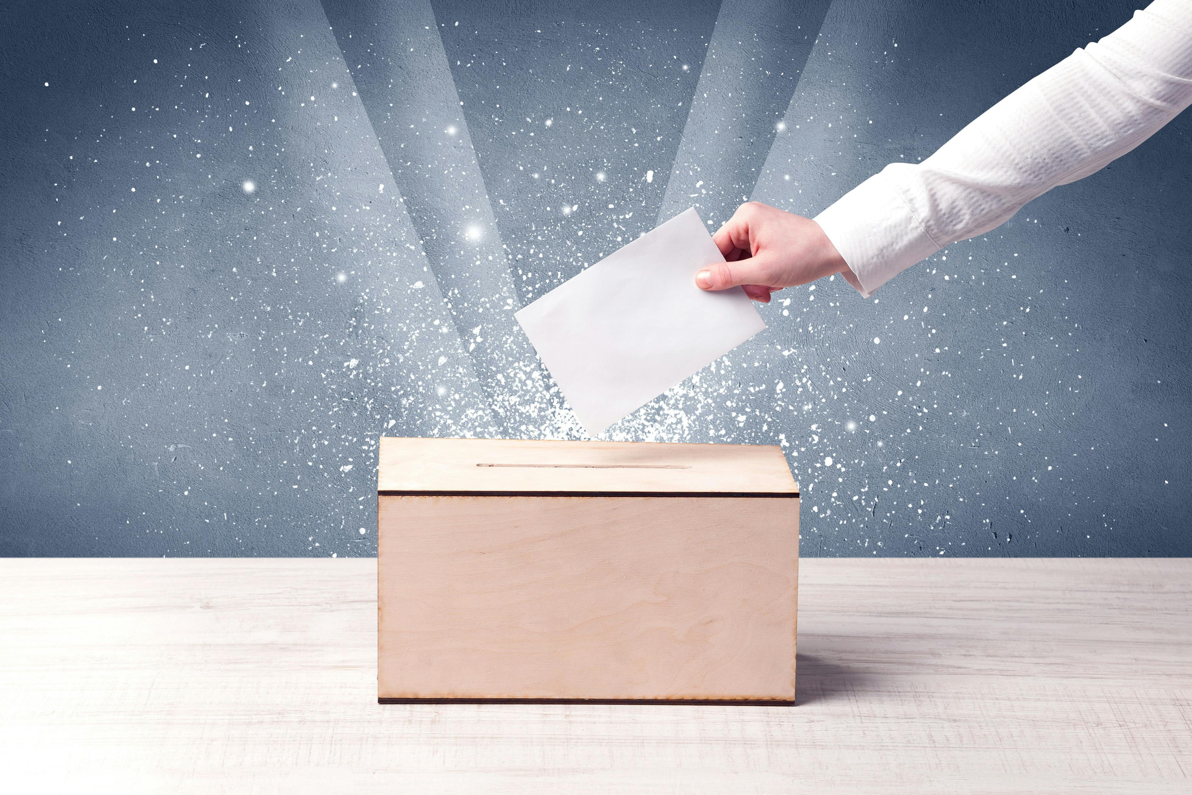 Person voting with a ballot box