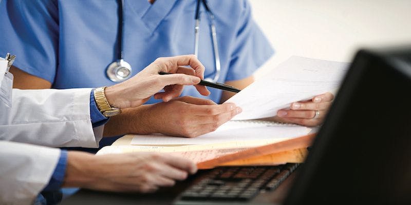 health care professionals are looking at documents