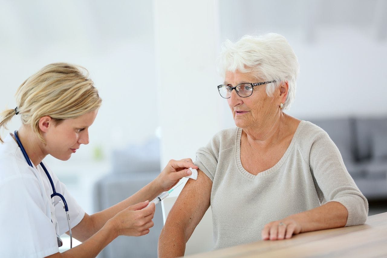 older woman receiving subcutaneous injection by a doctor