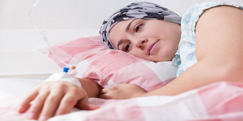 woman with cancer receiving iv in hospital bed